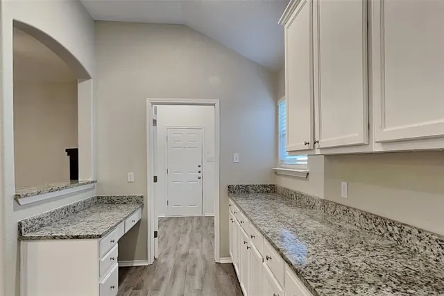 a kitchen with granite countertop cabinets and utility