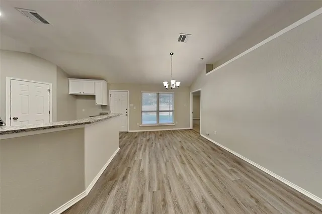 a view of a kitchen with wooden floor and a window