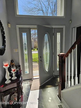 a view of entryway and hall with wooden floor