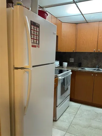a kitchen with a refrigerator and a sink