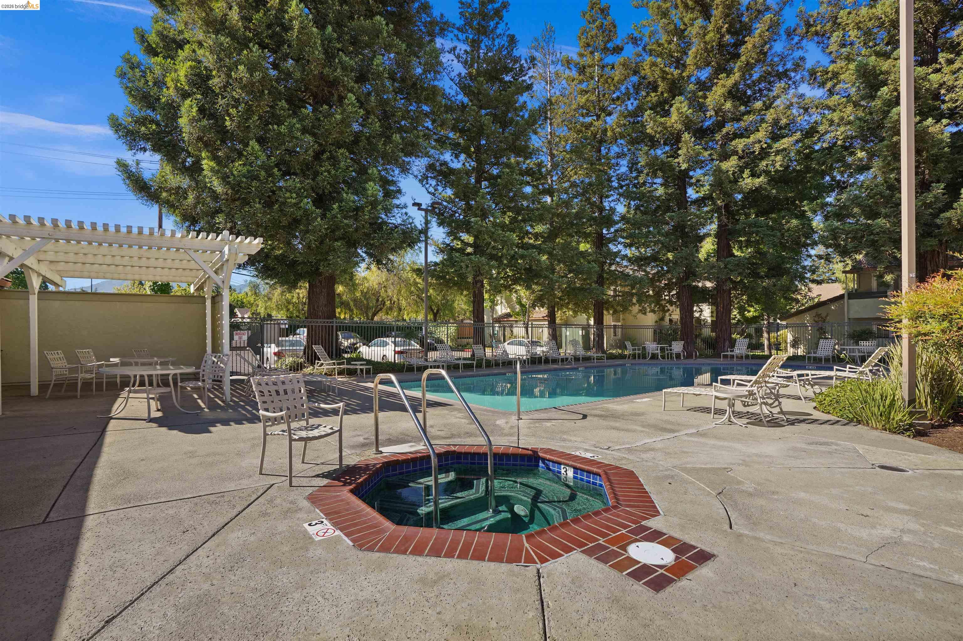 1505 Kirker Pass Road, Unit 214 Concord, CA 94521 - Photo 51 of 55 Community pool area featuring a built-in spa with brick coping, an expansive swimming pool, and concrete decking