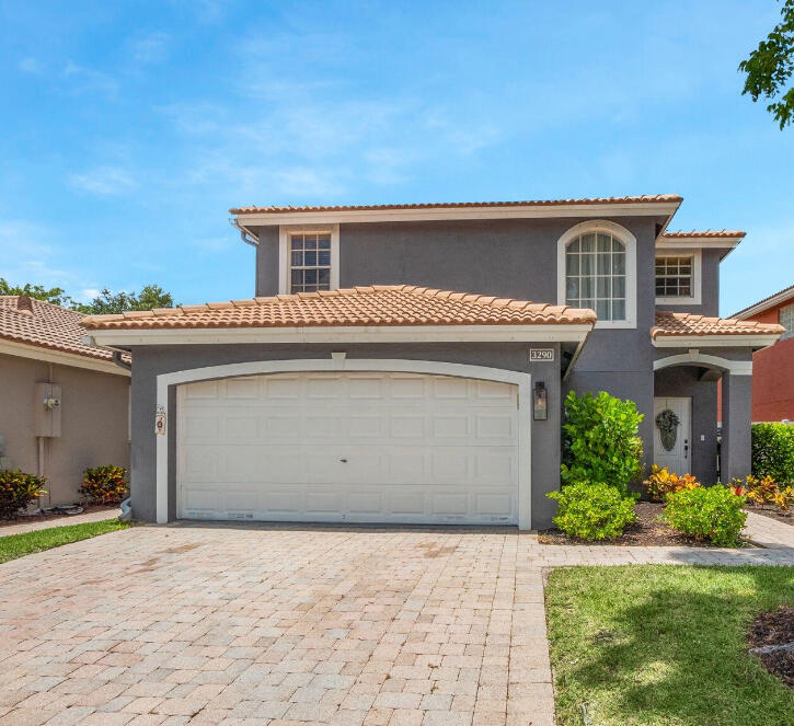 3290 Turtle Cove West Palm Beach, FL 33411 - Photo 1 of 55 a front view of a house with a yard and garage