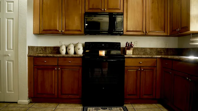 a kitchen with granite countertop cabinets and black appliances