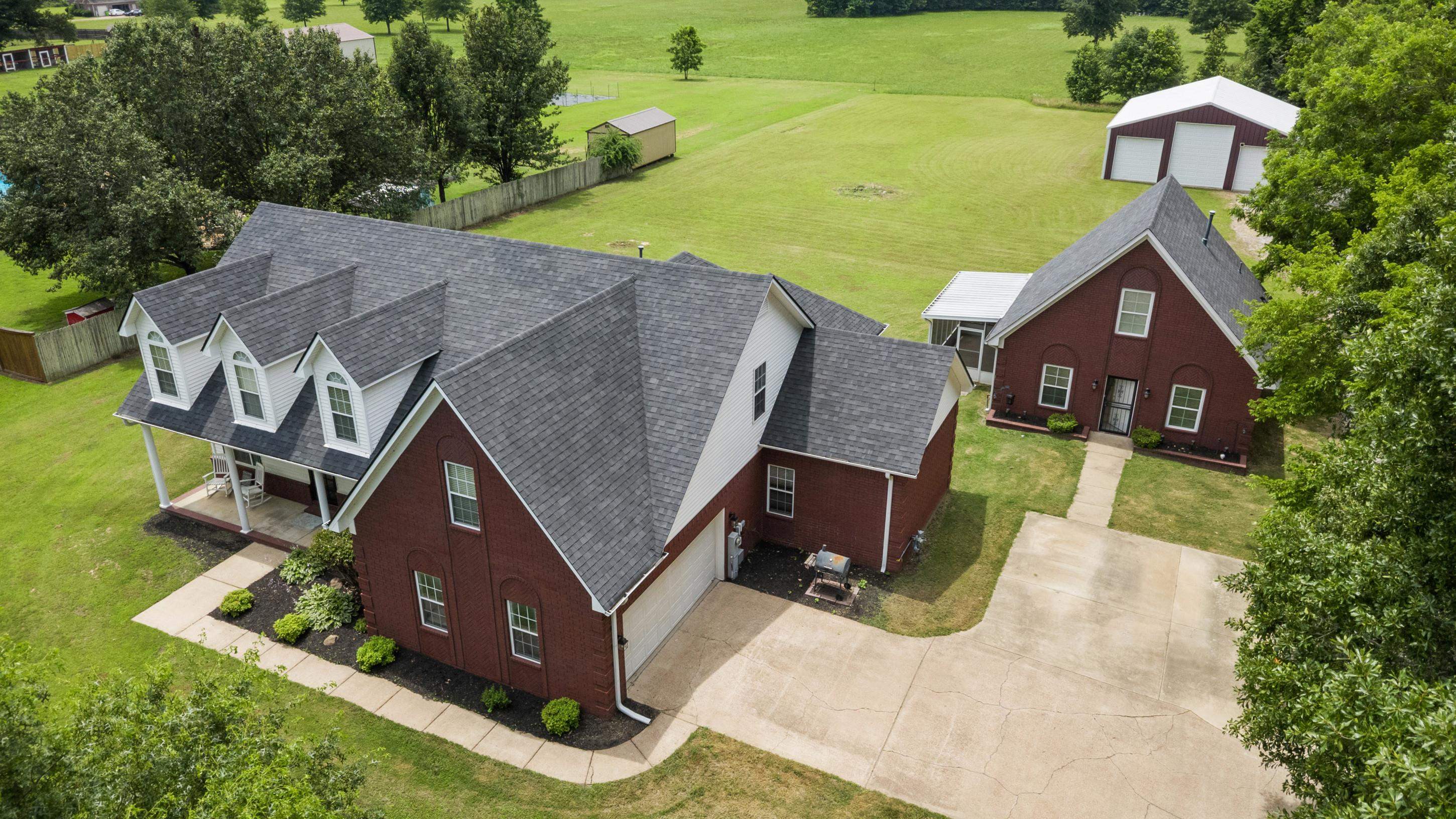7757 Brunswick Road Millington, TN 38053 - Photo 1 of 40 Expansive property featuring a brick main residence with a front porch and dormer windows, an attached garage, and a separate brick structure
