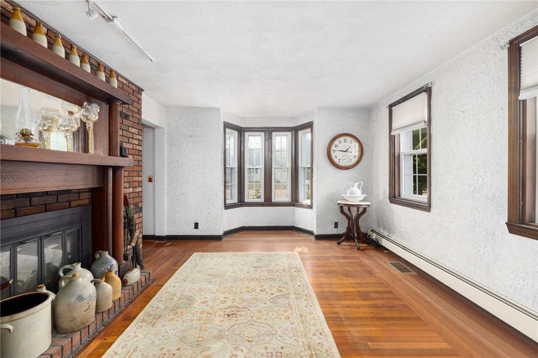 786 Sandy Lane Warwick, RI 02889 - Photo 9 of 26 The living room offers hardwood floors, baseboard heating and multiple windows for lots of natural light.
