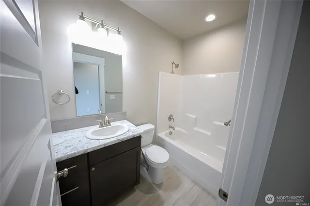 a bathroom with a sink a toilet a tub and a mirror