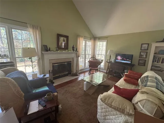 a living room with furniture a rug and kitchen view