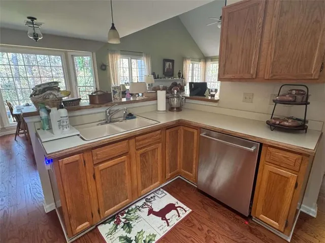 a kitchen with stainless steel appliances granite countertop a sink a stove and a wooden floor
