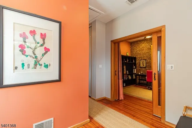 a view of a hallway with wooden floor and a workspace