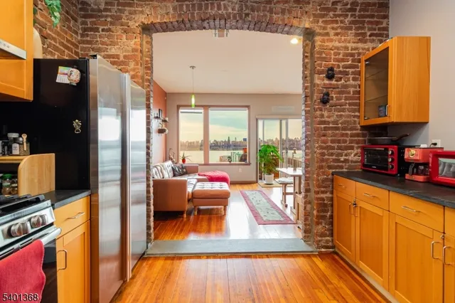 a living room with furniture a wooden floor and next to a window