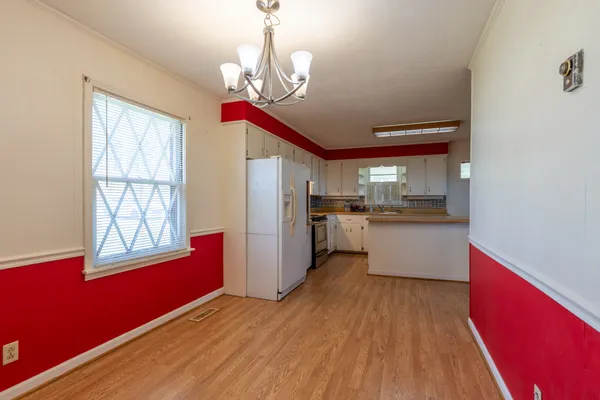 a open kitchen with stainless steel appliances granite countertop a refrigerator a stove top oven a sink dishwasher and wooden floor