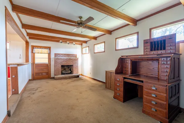 a view of an empty room with fireplace and a window