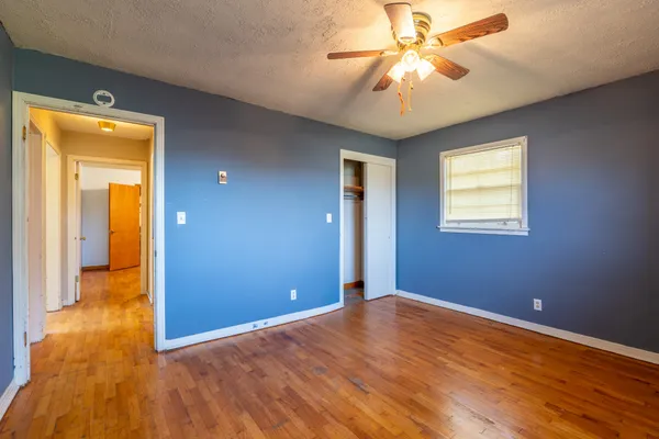 a view of empty room with window and wooden floor