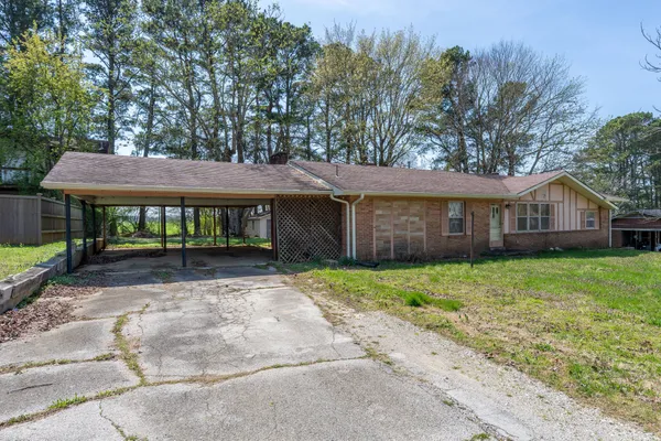 a view of a house with a yard and large tree