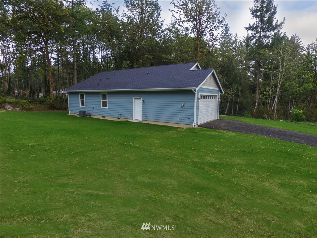 16716 Erickson Road Southwest Longbranch, WA 98351 - Photo 15 of 17 a view of a yard in front of a house with large trees