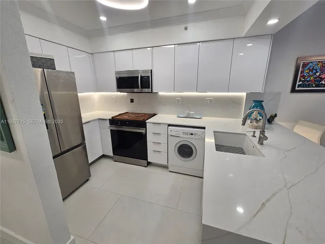 a utility room with dryer washer and a view of living room
