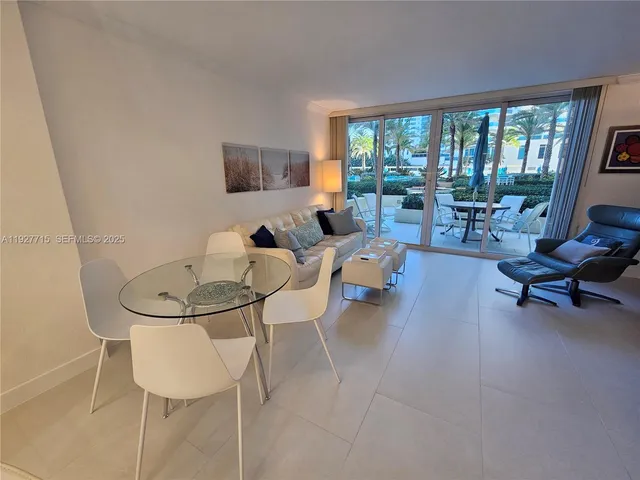 a living room with furniture and a floor to ceiling window