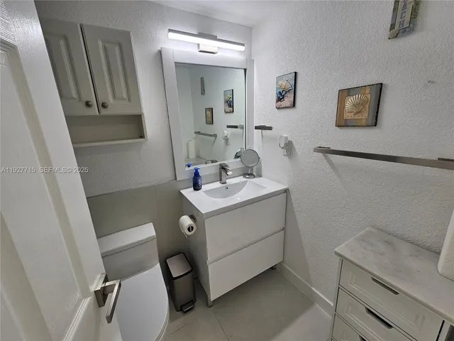 a bathroom with a sink toilet and mirror