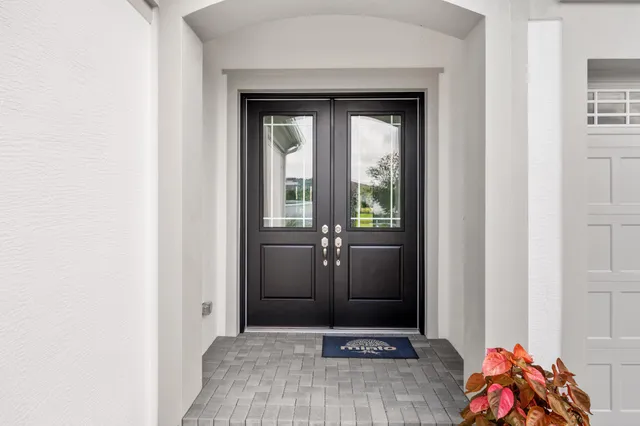 a view of a hallway with wooden floor and a bathroom