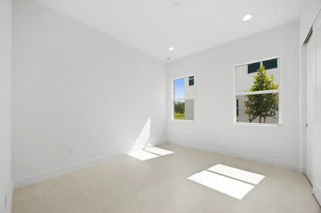 a view of a patio with couches table and chairs under an umbrella with a big yard