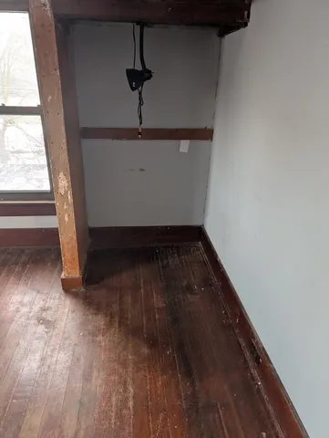 wooden floor in an empty room with a window