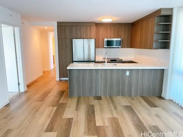 a kitchen with stainless steel appliances a stove top oven a sink and a refrigerator