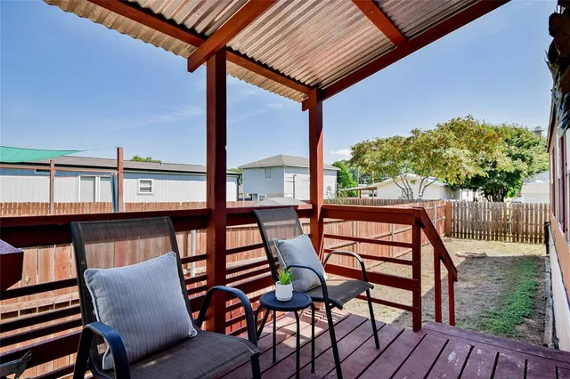 a view of chairs and wooden floor in front of a house