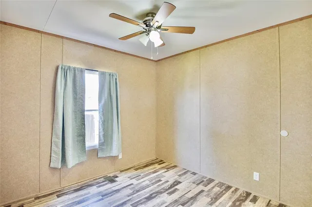 an empty room with windows and fan