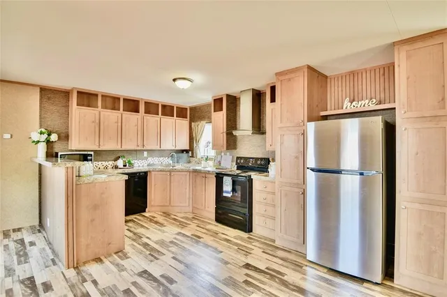 a kitchen with a refrigerator a stove and a wooden floor