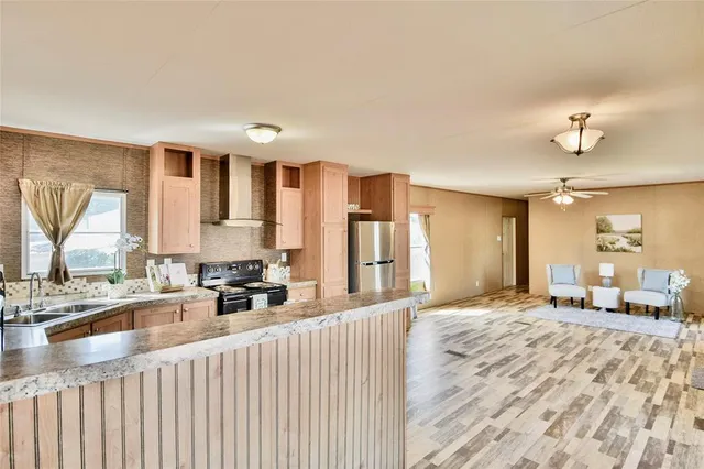 a kitchen with stainless steel appliances granite countertop a stove a sink and a refrigerator