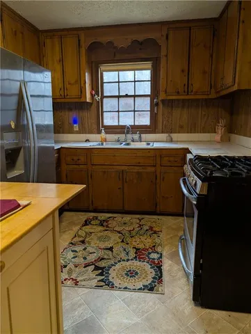 a kitchen with kitchen island granite countertop a sink stove and cabinets