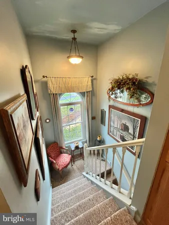 a view of a livingroom with furniture staircase and a chandelier
