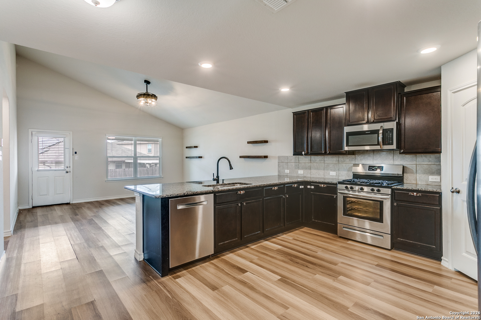 2615 Yaupon Ranch San Antonio, TX 78244 - Photo 9 of 25 a kitchen with stainless steel appliances granite countertop a stove cabinets and refrigerator