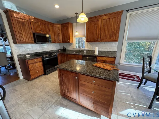 a kitchen with granite countertop wooden cabinets stainless steel appliances a window and a sink