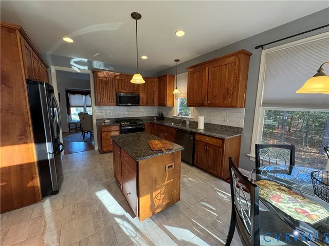 a kitchen with stainless steel appliances granite countertop a stove a sink a refrigerator and a oven