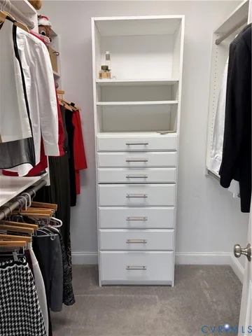 a view of walk in closet with clothes and shoes