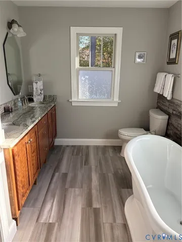 a bathroom with a granite countertop sink a toilet and bathtub