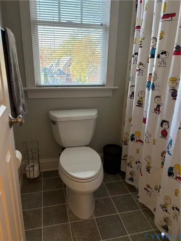 a bathroom with a toilet and a shower curtain