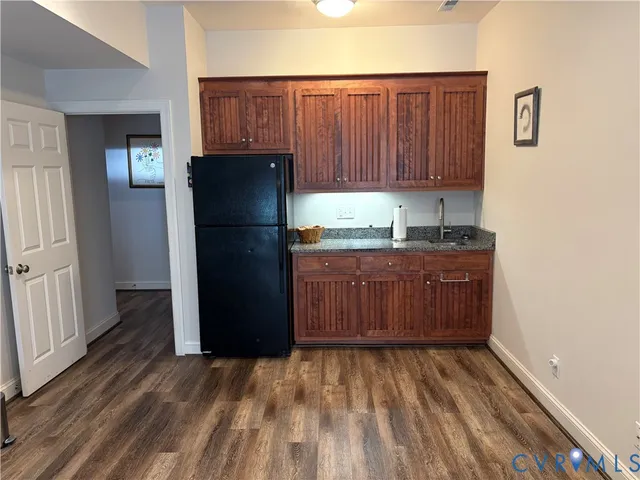 a kitchen with a refrigerator and wooden cabinets