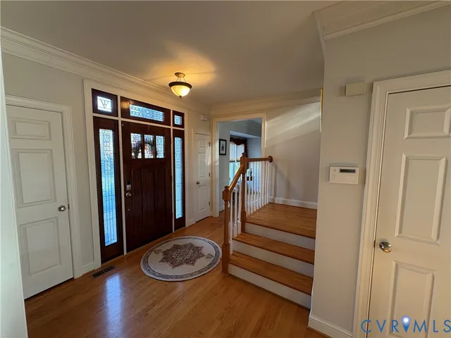 a view of entryway and hall with wooden floor