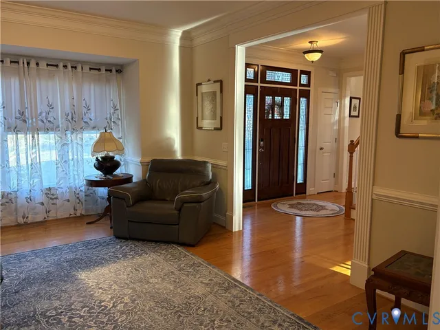 a living room with furniture a window and a wooden floor