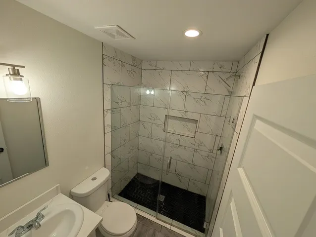 a bathroom with a toilet and a shower