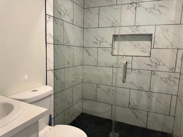 a bathroom with a toilet and a shower