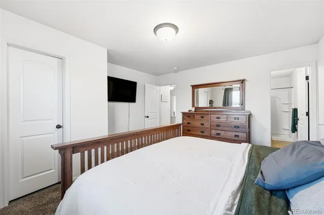 a bedroom with a bed a mirror and a flat screen television