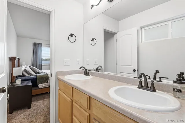 a en suite bathroom with a double vanity sink and a mirror
