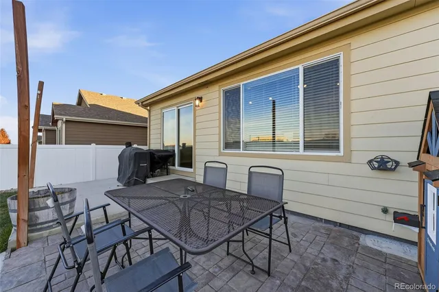 a view of a patio with table and chairs and barbeque