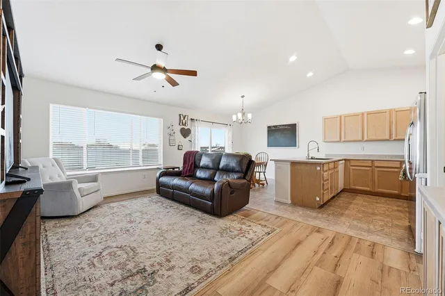 a living room with furniture kitchen view and a large window