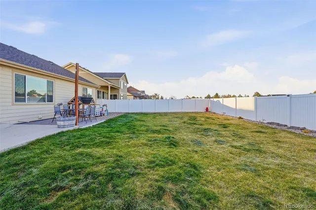 a view of a swimming pool with lawn chairs and a yard