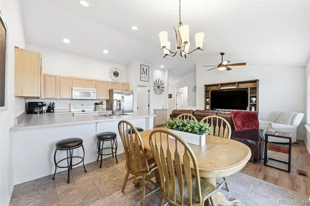 a view of a dining room with furniture a chandelier and wooden floor
