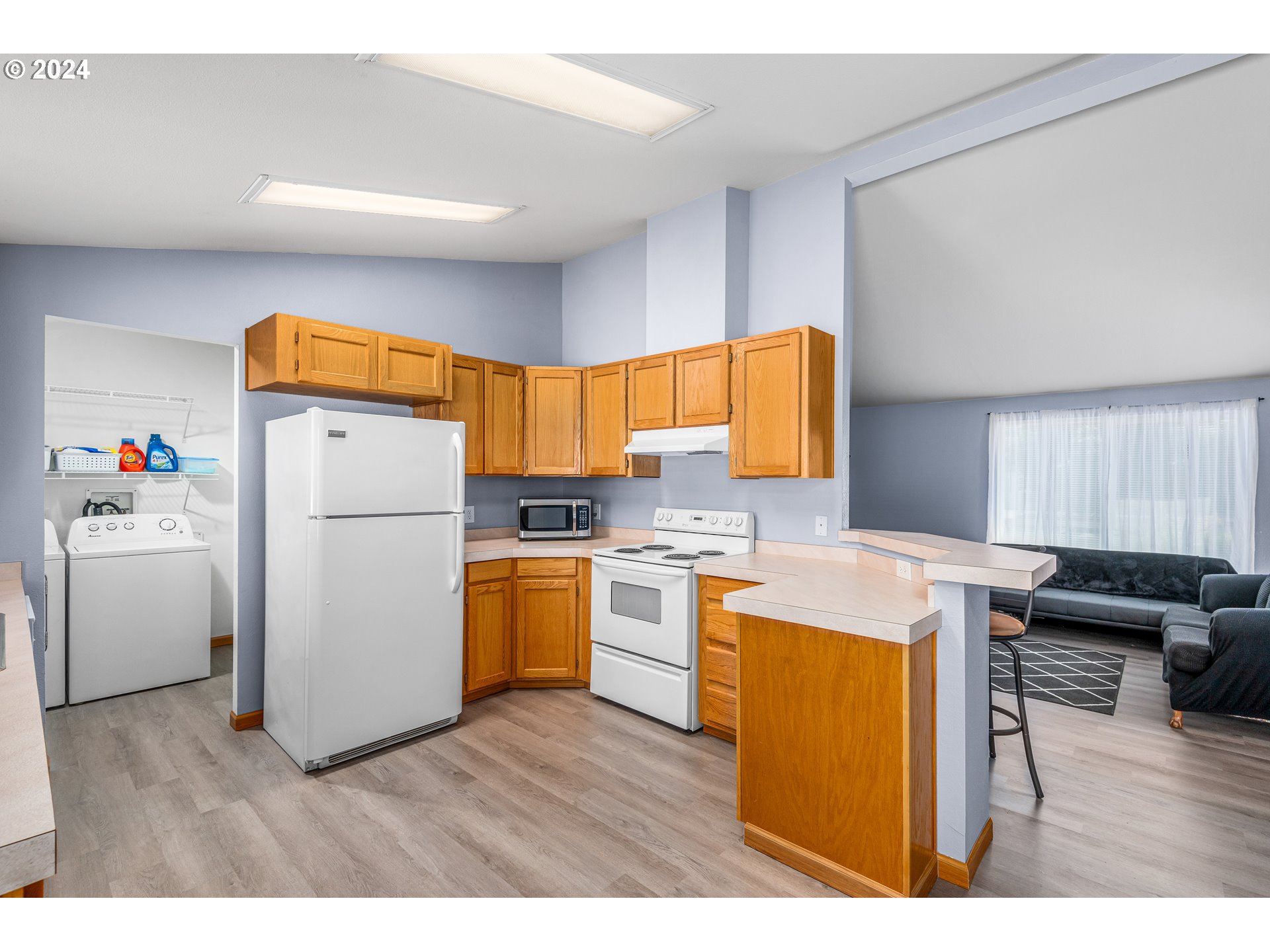 2606 Maia Loop Springfield, OR 97477 - Photo 10 of 29 a open kitchen with a refrigerator a stove top oven a sink and dishwasher with wooden floor